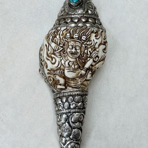 Hand-carved Conch Shell Vajrapani / Chakna Dorje /Chador is a fierce protector deity with German Silver Inlay. 100 % Handmade from Nepal