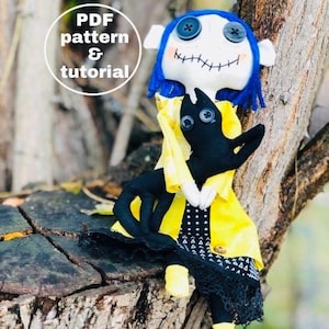 May include: A handmade doll with blue hair, a yellow jacket, and a black cat. The doll has stitched-on eyes and a stitched-on mouth. The doll is holding the cat in its arms. The doll is sitting on a tree stump. The image includes the text "PDF pattern & tutorial".