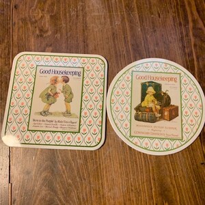 May include: Two vintage Good Housekeeping magazine coasters with a floral design. One coaster features a vintage illustration of two children, and the other features a vintage illustration of a child with luggage.