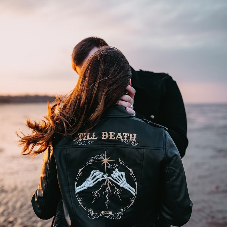 Couple wearing black leather jackets on theri elopment photoshoot on a beach