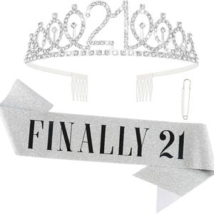 May include: A silver tiara with the number "21" in rhinestones and a matching silver glitter sash that reads "FINALLY 21" in black lettering. A pearl-beaded pin is also included. Perfect for a 21st birthday celebration.