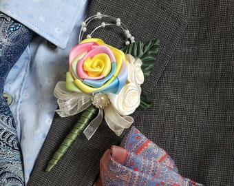 May include: A gray suit jacket with a rainbow silk rose boutonniere and a paisley pocket square.