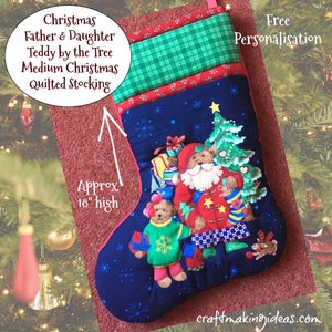 May include: A medium Christmas quilted stocking with a navy blue background, featuring a teddy bear Santa Claus and a teddy bear child. The stocking is approximately 46 cm high and has a green and red patterned top. Text on the stocking reads "Christmas Father & Daughter Teddy by the Tree".