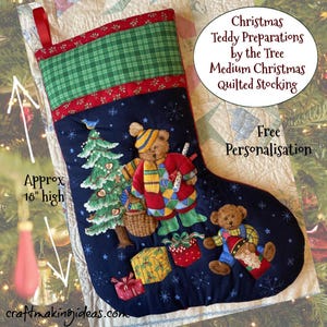 May include: A navy blue Christmas stocking with teddy bear and Christmas tree appliqués. The top is green plaid, with red trim. The stocking is approximately 46 cm high and features the text "Christmas Teddy Preparations by the Tree".