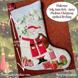 May include: A medium Christmas quilted stocking with a Santa Claus design. The stocking is approximately 46 cm high and features a winter landscape scene. The text "Jolly Saint Nick - Santa" is displayed.