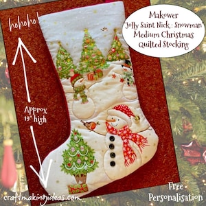 May include: A quilted Christmas stocking featuring a snowman and Christmas tree design. The stocking is approximately 48 cm high. The text reads "Makower Jolly Saint Nick: Snowman Medium Christmas Quilted Stocking".