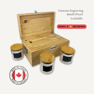 Könnte beinhalten: Eine hellfarbene Bambusbox mit Scharnierdeckel, geöffnet, um einen Innenraum mit einer kreisförmigen Vertiefung und einem kleinen Loch freizugeben. Die Box wird von drei Gläsern mit Holzdeckeln und schwarzen Etiketten begleitet. Der Text auf dem Bild lautet "Custom Engraving, Smell-Proof, Lockable" und "3000+ 5 REVIEWS!"