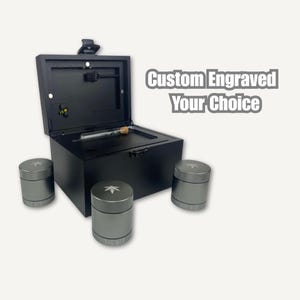 May include: A black wooden box with an open lid, a glass tube, and three silver containers. The containers have a leaf design on the lid and the text "THE BEE" on the bottom. The text "Custom Engraved Your Choice" is also visible.