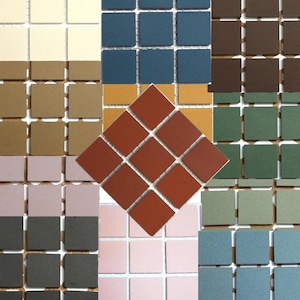 May include: A collection of 10 different coloured ceramic tiles, each with a square grid pattern. The tiles are arranged in a grid pattern, with each tile being a different colour. The colours include beige, brown, dark blue, light blue, green, pink, red, and white.
