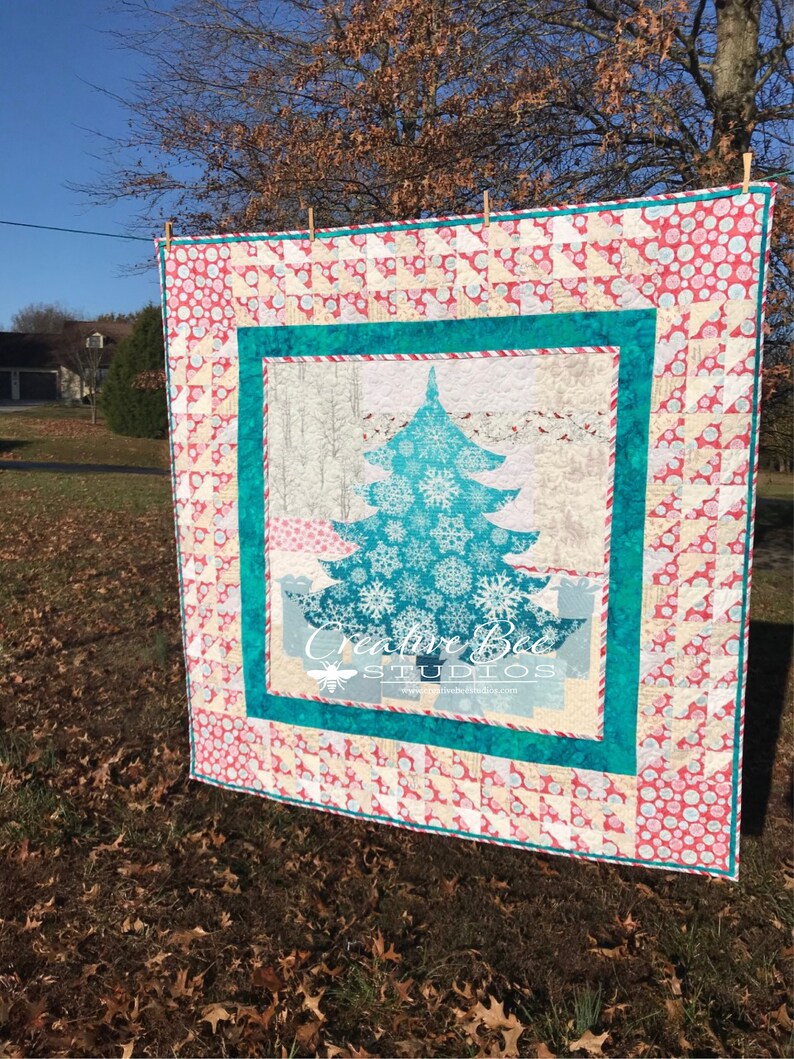 Sunny view of Joyful Christmas tree quilt hanging from clothesline.