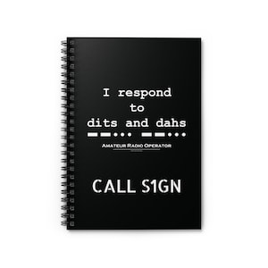 May include: A black spiral-bound notebook with white text that reads "I respond to dits and dahs" and "AMATEUR RADIO OPERATOR". Below the text is "CALL SIGN". The notebook is designed for amateur radio enthusiasts.