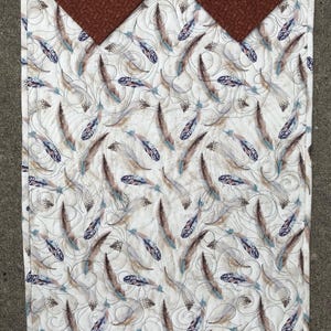 Back of quilt showing hanging method and feather focus fabric.