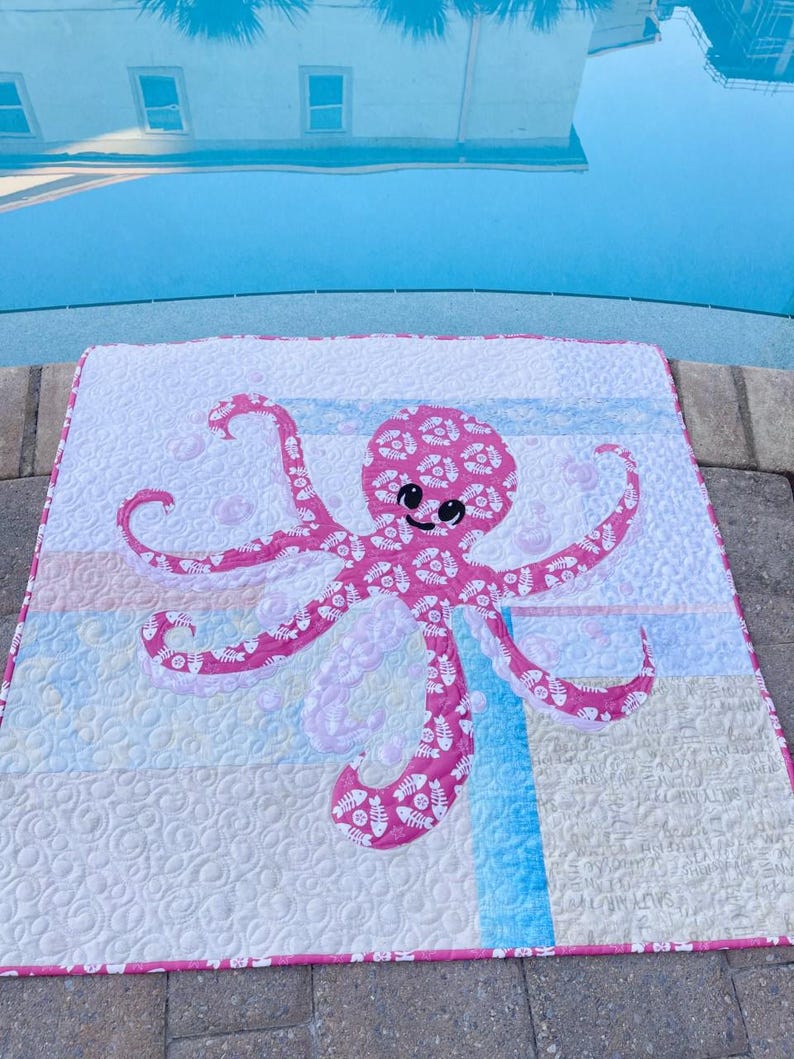 Pink baby octopus applique quilt made with both sides of pink fishbone and sand dollar fabric.