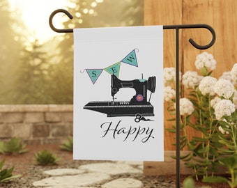 May include: A white garden flag with a black silhouette of a sewing machine and the word "Sew" in colorful bunting above it. The text "Happy" is written below the machine.