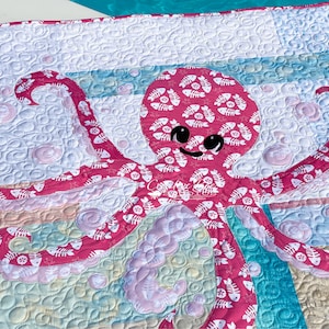 Baby octopus applique quilt shown at poolside.