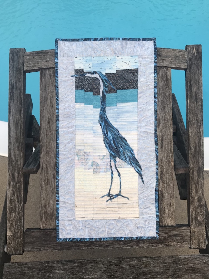 Lord Stanley Great Blue Heron quilt shown on beach chair at poolside.