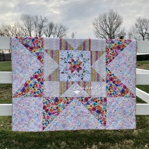 Image of quilt on fence at dawn.