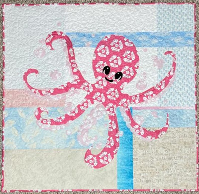 Octopus applique quilt pattern made with both sides of pink fishbone and sand dollar fabric.