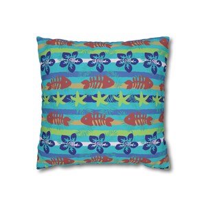 May include: Square throw pillow with a tropical pattern. The design features horizontal stripes in shades of blue and green, with repeating motifs of red fish skeletons, blue flowers, and yellow starfish. The pillow is a square shape.