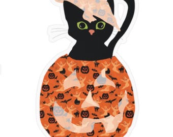May include: A die-cut sticker featuring a black cat with bright green eyes wearing a light peach-colored hat. The cat is positioned inside a round orange pumpkin decorated with a repeating pattern of black bats, cats, and jack-o'-lanterns.