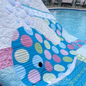 Bubbles the baby whale quilt at poolside.