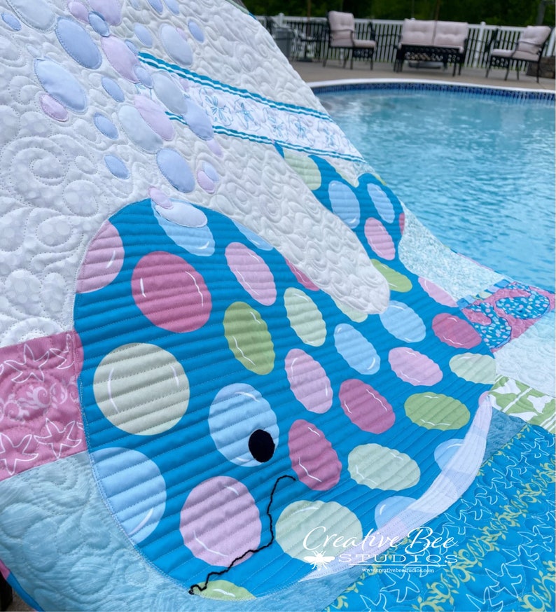 Bubbles the baby whale quilt at poolside.