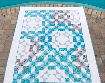 May include: A rectangular quilt featuring a geometric patchwork design in shades of turquoise, light blue, and white. The pattern consists of repeating star and square blocks with a white border. The text Creative Bee Studios is visible.