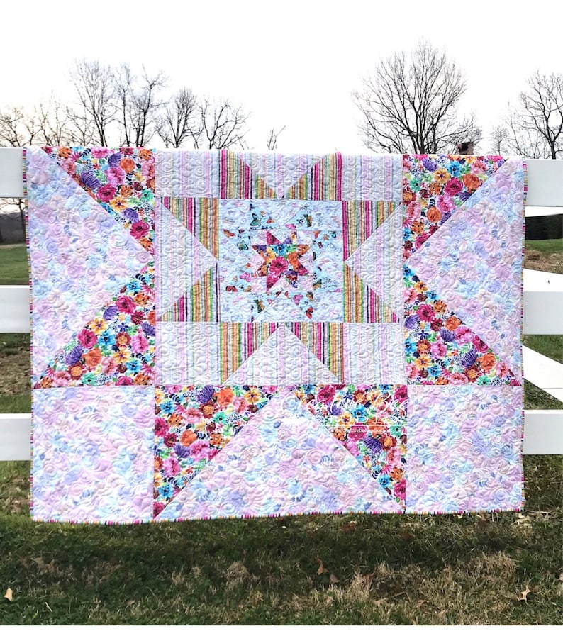 VariLovable Star Quilt hanging on white fence.