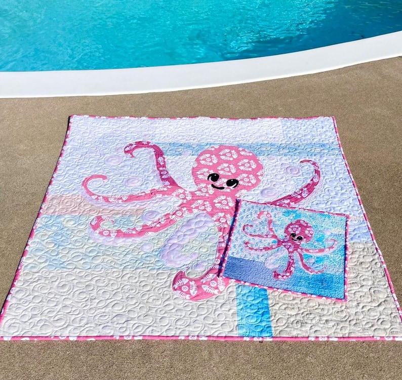 PINKY and Pinky Mini octopus applique quilt pattern made with both sides of pink fishbone and sand dollar fabric shown at poolside.