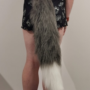 May include: A grey and white furry tail with a black and white mushroom print on the shorts.