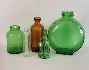 Lote vintage de 5 botellas de colores, tamaños variados: verde, marrón y transparente.