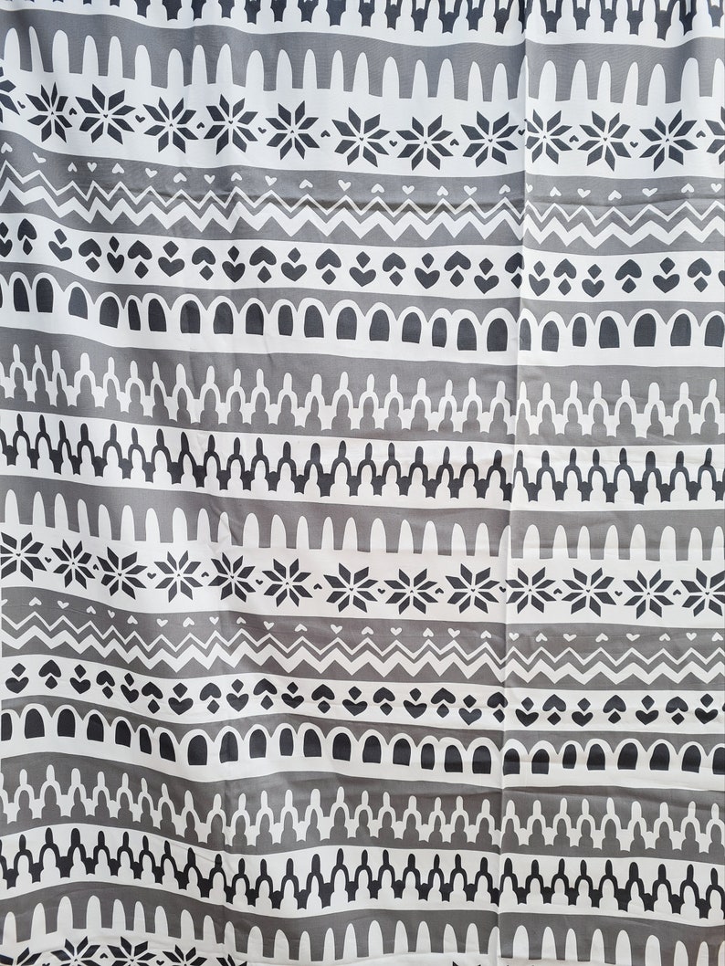 May include: Gray and white fabric with a repeating geometric pattern. The pattern includes snowflakes, zigzags, arches, and other abstract shapes.