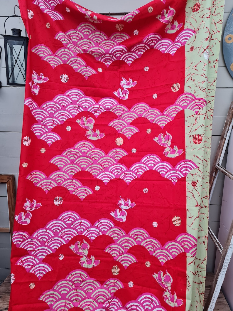May include: Red fabric with a repeating pattern of pink and white waves, stylized fish, and the Chinese character for "double happiness".
