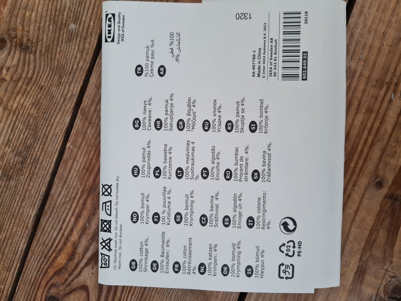 May include: A white label with black text listing the composition of the fabric in various languages. The label includes the text "100% cotton" and "Shrinkage 4%" in English, as well as the text "100% pamuk" and "&Ccedil;ekme payı %4" in Turkish.