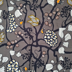 May include: A gray fabric with a repeating pattern of white flowers, black branches, and yellow and brown circles. The pattern is stylized and abstract.