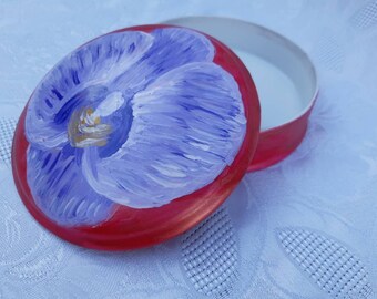 Round jewelery box in French white porcelain with its flower on a red background