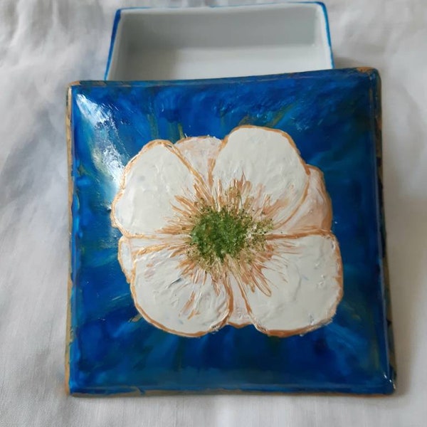 Boite à bijoux carrée en porcelaine française décorée avec  un fond bleu et une fleur blanche : création artisanale