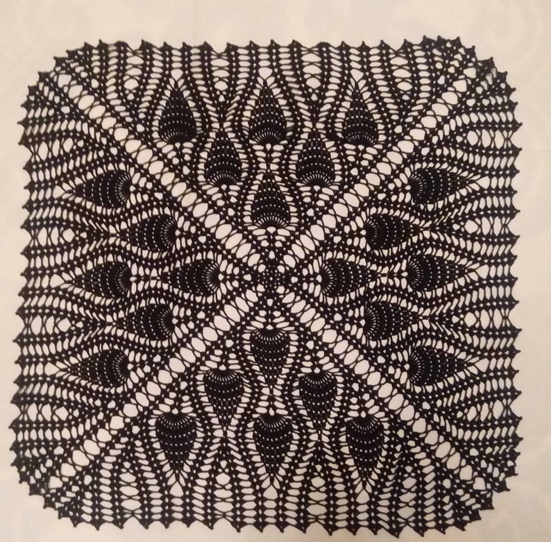May include: A black crocheted doily with a delicate, intricate design featuring a repeating pattern of stylized leaves.
