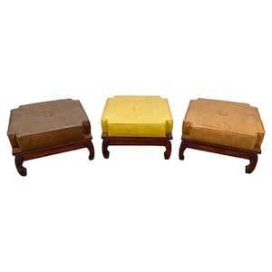 May include: Three square ottomans with wooden legs and brown, yellow, and brown upholstery.