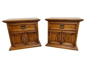 May include: A pair of wooden nightstands with a drawer and two doors. Each nightstand has a dark wood finish and brass hardware.
