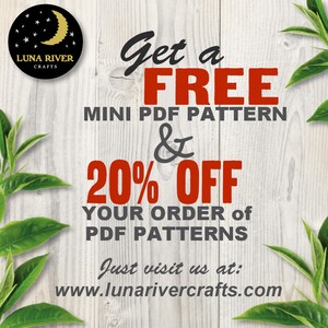 May include: A white wooden background with a red and black graphic that says "Get a FREE MINI PDF PATTERN & 20% OFF YOUR ORDER of PDF PATTERNS. Just visit us at: www.lunarivercrafts.com". The graphic is surrounded by green leaves.