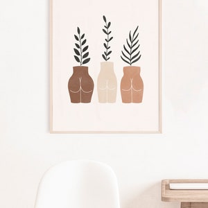 May include: Three abstract vases with different skin tones, each with a leafy plant growing from the top. The vases are in a minimalist style and are a light brown, beige, and terracotta color.