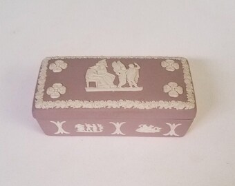 Wedgwood lilac Jasperware rectangular lidded trinket box featuring semi-nude woman, cherubs, and people in classical garb