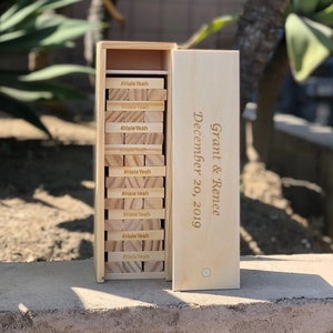 May include: A wooden box with a stack of wooden blocks inside. The blocks are engraved with the hashtag "#HaleYeah". The box is also engraved with the text "Grant & Renee December 20, 2019".