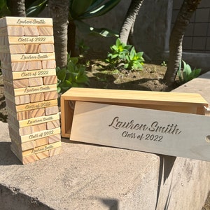 May include: A wooden box with a stack of wooden blocks. The blocks and box are engraved with the text "Lauren Smith Class of 2022".