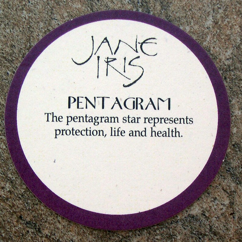 May include: A white coaster with a purple border and the text "JANE IRIS PENTAGRAM The pentagram star represents protection, life and health."