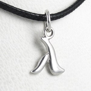 Puede incluir: Un collar con un colgante de plata con un dije de la letra 'A' estilizada en un cordón negro.