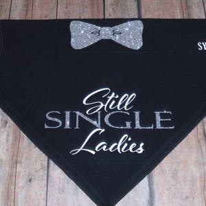 May include: Black dog bandana with silver glitter bow tie and the text "Still Single Ladies" in silver glitter.