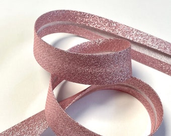 Cinta al bies de lurex color rosa polvo metalizado, predoblada, de 18 mm de ancho, vendida por metros.