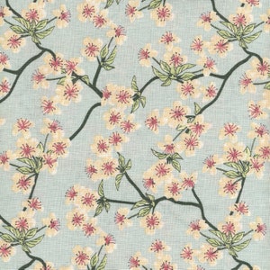 May include: A repeating pattern of light yellow cherry blossoms with pink centers and green leaves on a light blue background. Dark green branches weave throughout the design, creating a floral textile pattern.